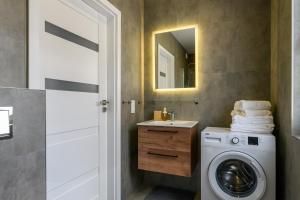 Un baño con lavadora y lavabo. en NordApart Słoneczna Dolina 25, en Jastrzębia Góra