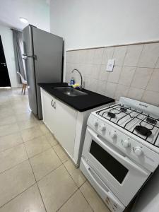 a kitchen with a stove and a sink and a refrigerator at El elegido por parejas y estudiantes in Resistencia