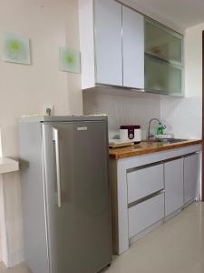 eine Küche mit einem Kühlschrank aus Edelstahl und weißen Schränken in der Unterkunft Studio Lavender Galeri Ciumbuleuit 2 in Bandung