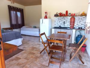 ein Wohnzimmer mit einem Tisch und einem Kühlschrank in der Unterkunft Recanto Cachoeiras de Ibicoara in Ibicoara
