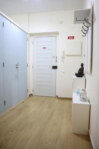 um quarto com uma porta branca e uma pessoa sentada numa mesa em Navio Azul Apartment no Funchal