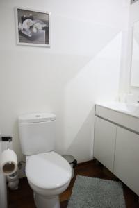a white bathroom with a toilet and a sink at Navio Azul Apartment in Funchal