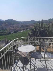 stół i 2 krzesła na balkonie w obiekcie Dimora Palma di Barolo w mieście Barolo