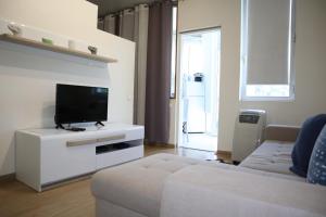 a living room with a couch and a flat screen tv at Navio Azul Apartment in Funchal