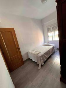 a bedroom with a bed and a wooden door at Piso céntrico en Paterna in Paterna