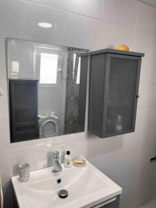 a white bathroom with a sink and a mirror at Piso céntrico en Paterna in Paterna