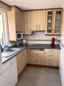 a kitchen with wooden cabinets and a red appliance at Piso céntrico en Paterna in Paterna