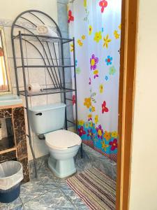 baño con aseo y pared de flores en Apartamento Tamar, en Quepos