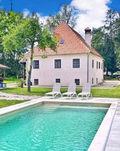 two chairs and a swimming pool in front of a house at Villa Taborec in Samobor