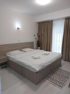 Un dormitorio con una cama grande y una ventana en Hotel Babilon, en Bucarest