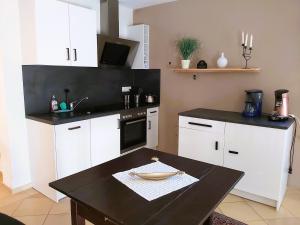 a kitchen with white cabinets and a black counter top at Waldwinkel in Treuchtlingen
