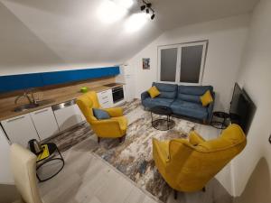 uma sala de estar com cadeiras amarelas e um sofá azul em Sovran's dream 2bedroom Apt 10min wak from center em Pristina