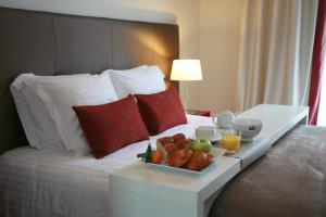 a tray of food on a bed in a hotel room at Hôtel La Résidence des Artistes in Roscoff