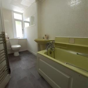 a bathroom with a tub and a sink and a toilet at Peaceful and Stunning Waterside Location in Helensburgh +21 photos