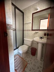 a bathroom with a toilet and a sink and a mirror at H-OSTELLO LA MERIDIANA in Villa de Leyva +96 photos