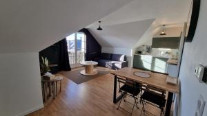 eine Küche und ein Wohnzimmer mit einem Tisch und Stühlen in der Unterkunft Le Saint Thomas in Crépy-en-Valois