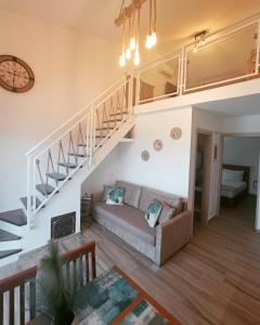 sala de estar con sofá y escaleras en Enigma Boutique Houses Koxyli en Marmarion