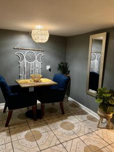 une salle à manger avec une table, des chaises et un miroir dans l'établissement Chicago-Pilsen Boho apartment with Free parking - Unit C, à Chicago