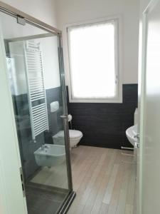 a bathroom with a glass shower and a toilet at Appartamento Vivaldi! in Cento