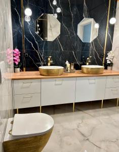 a bathroom with two sinks and a toilet at Golden Luxury Suite in Nowy Dwór Mazowiecki
