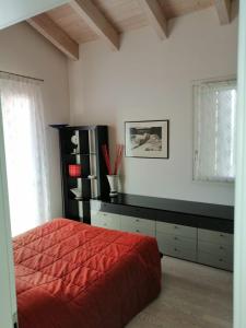 a bedroom with a red bed and a black shelf at Appartamento Vivaldi! in Cento