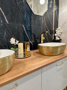 Golden Luxury Suite في نوفي دفور مازوفييتسكي: حمام مع مغسلتين على كونتر خشبي