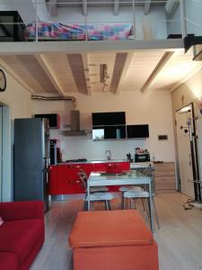 a kitchen with red cabinets and a table and chairs at Appartamento Vivaldi! in Cento