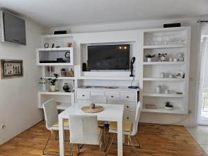 a white dining room with a white table and chairs at The Garden Nook in Zagreb