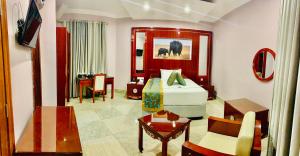 Royal Tughimbe Hotel في ميبيا: غرفة الفندق بسرير وطاولة