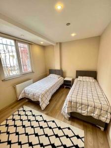 2 camas en una habitación con 2 ventanas en Şirinevler Büyük Daire, en Estambul
