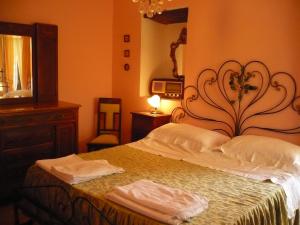 1 dormitorio con 1 cama con 2 toallas en Agriturismo Biologico la Casa degli Gnomi, en Ortezzano