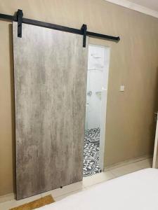 a sliding shower door in a bathroom with a shower at Central Gabs Oasis: 2BR-Retreat in Gaborone