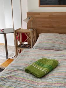 a green blanket on a bed in a bedroom at Wein4tel-Apartments in Auersthal