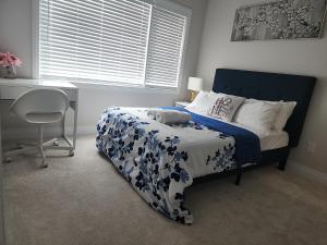 a bedroom with a bed with a blue and white bedspread at Dorothy's Place in Ottawa