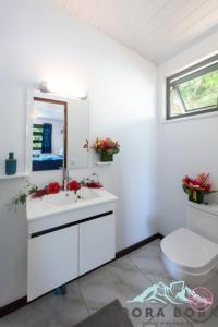 a white bathroom with a sink and a toilet at Matira Beach Raitea 2 in Bora Bora