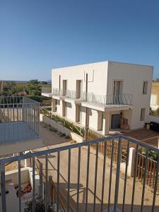 con balcone e vista su un edificio bianco. di La casetta GioSa sullo Stagnone a Marsala