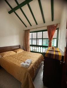 a bedroom with two beds and a window at H-OSTELLO LA MERIDIANA in Villa de Leyva