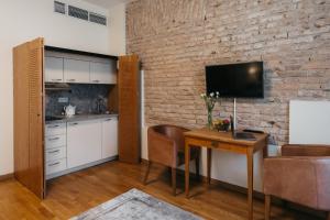 a kitchen and dining room with a table and a tv at CATHEDRAL Old Town Suites in Vilnius