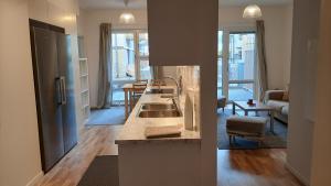 a kitchen with a sink and a living room at Stockholm Private Rooms in Shared Lovely, Amazing, Modern Apartment +Garden +BBQ in Stockholm