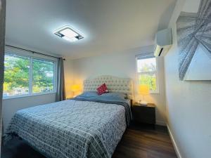 a bedroom with a bed and two windows at Modern Home with Air Conditioners Near Bitter Lake in Seattle