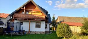 a house with a balcony on top of a yard at Chalupa Zeleznik in Zuberec