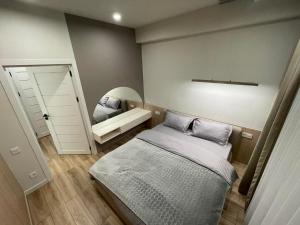 a small bedroom with a bed and a mirror at Tomas apartments in Chişinău
