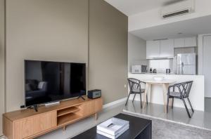 a living room with a large television and a table at Beautiful 1BR Apartment in Singapore! in Singapore
