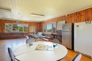 a room with a table and a refrigerator and a piano at HI - Truro Hostel in Truro