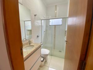 ein Bad mit einer Dusche, einem Waschbecken und einem WC in der Unterkunft Casa no Centro da Cidade/Com ar condicionado in Marília