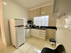 eine kleine Küche mit einem weißen Kühlschrank in der Unterkunft Casa no Centro da Cidade/Com ar condicionado in Marília