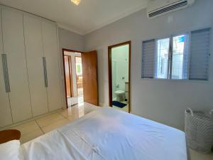 um grande quarto branco com uma cama grande em Casa no Centro da Cidade/Com ar condicionado em Marília