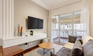 a living room with a couch and a flat screen tv at Tabas Apê estiloso no Jardim Botânico JB0002 in Rio de Janeiro