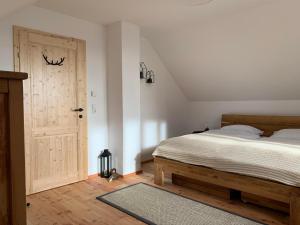 a bedroom with a bed and a wooden door at Almhütte mit Sonnenterrasse - Holzofen - Sauna in Bad Sankt Leonhard im Lavanttal