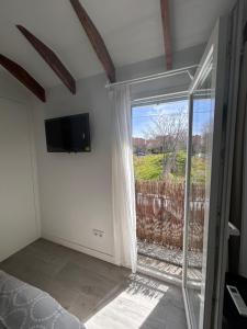 1 dormitorio con ventana grande y TV en Casa rústica en Madrid recién reformada, en Madrid